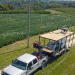 DJI Agras agricultural drone and fertilizer trailer setup on a farm in Wisconsin