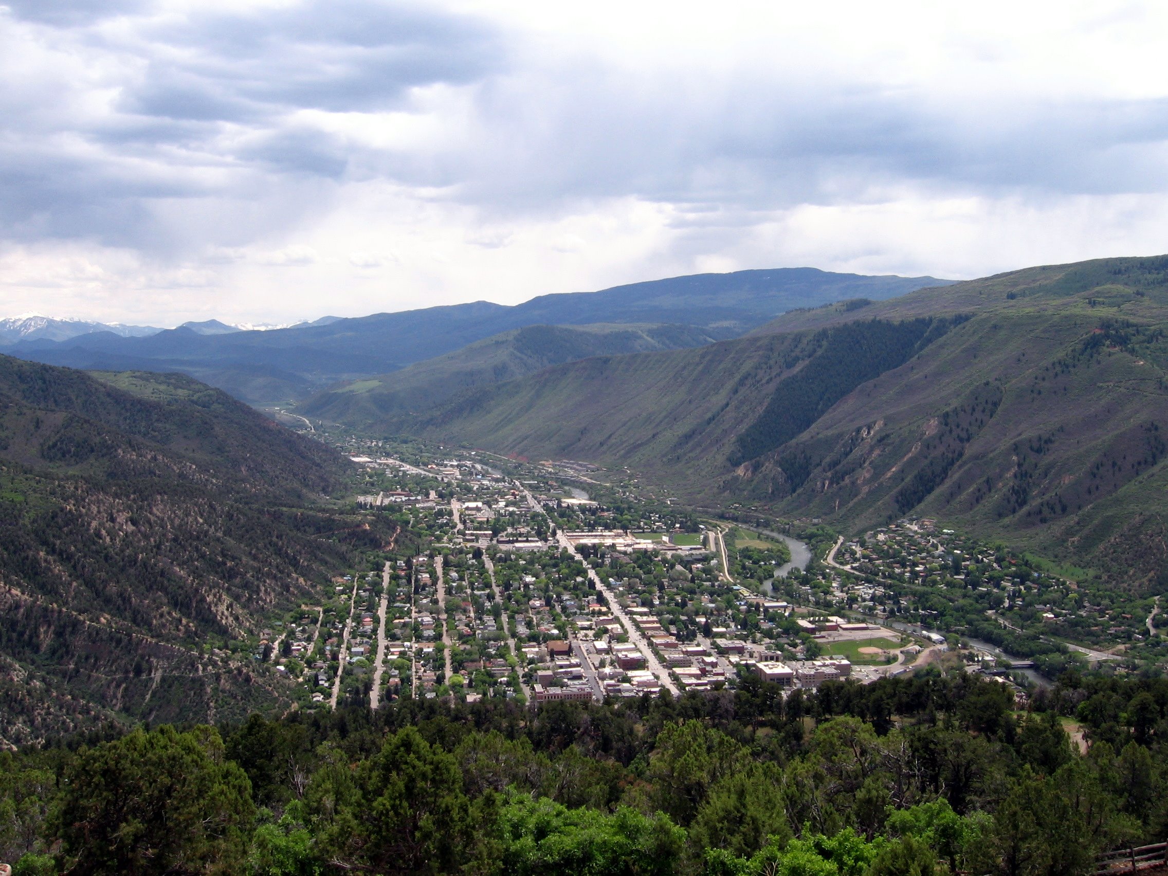 Aerial view of Glenwood Springs, Colorado, a small town in a Rocky Mountain river valley with mountains in the background
