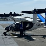 Joby S4 eVTOL aircraft (N545JX) on a New York City helipad with waterfront in the background