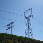 High voltage electric transmission lines stretching across countryside landscape