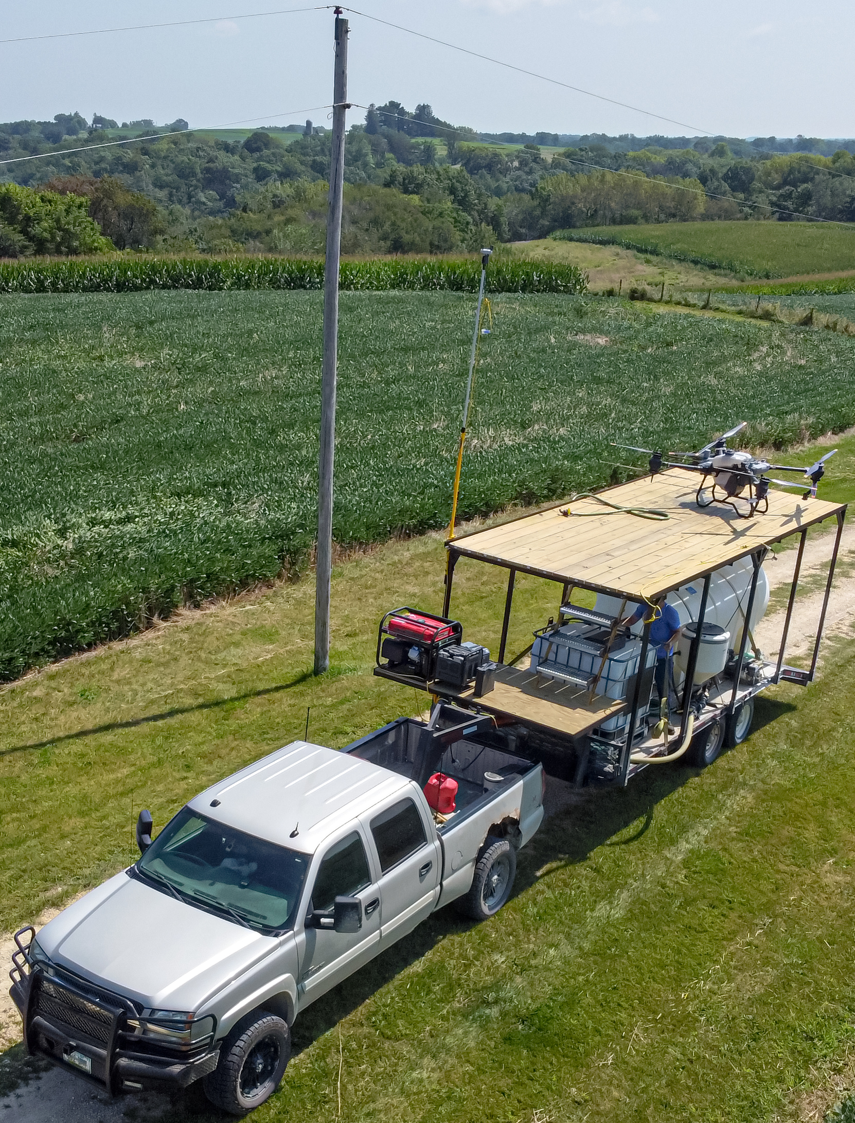 Drone crop fertilizer spraying configuration on a trailer